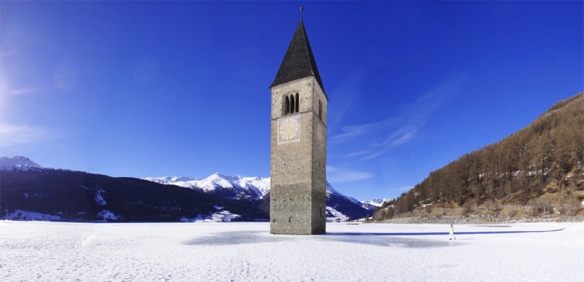 Reschensee im Winter mit dem Kirchturm von Graun